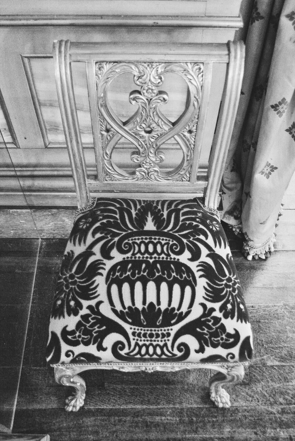 A detailed small chair in black and white at The Breakers mansion in Newport, Rhode Island.